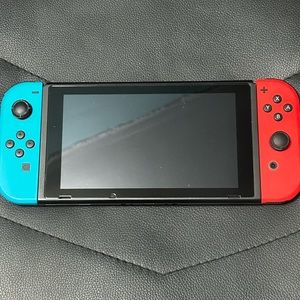 Selling Nintendo Switch with a case, one video game and a car charger